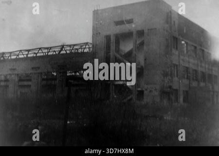 Slawjansk, Region Donezk, ukrainische SSR, Sowjetunion. 1943. Die Ruinen der Artem Armature-Isolator Factory (AIZ) nach der Befreiung der Stadt von der Nazi-Besatzung während des Zweiten Weltkriegs. Das Foto zeigt ein mehrstöckiges Industriebau mit durchgeblasenen Fenstern und einem zerstörten Dach. Eine freiliegende Treppe ist durch die leere Wand sichtbar. Das Skelett einer Werkstatt steht links. Dieses seltene Archivbild dokumentiert die katastrophale Zerstörung der Industrie im Donbass vor dem Wiederaufbau der Nachkriegszeit. Stockfoto