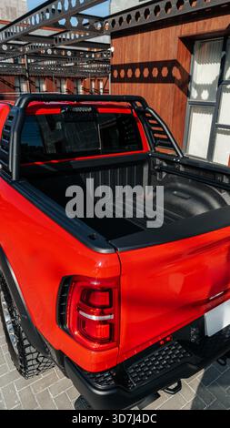 Hellroter Pickup-Truck, der tagsüber in modernem Außenbereich geparkt wird Stockfoto