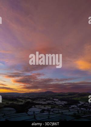 Wetter in Großbritannien: Klarer Himmel und sinkende Temperaturen haben einen Nachtfrost und schönen Sonnenaufgang in der Nähe des Dorfes Lixwm in Flintshire mit den Clwydian Range Hills in der Ferne hinterlassen, Nordwales 26. November 2025 , Flintshire, Wales ©DGDImages/Alamy Live News Stockfoto