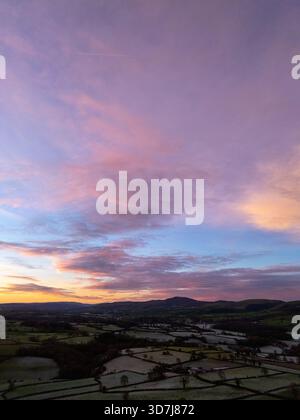 Wetter in Großbritannien: Klarer Himmel und sinkende Temperaturen haben einen Nachtfrost und schönen Sonnenaufgang in der Nähe des Dorfes Lixwm in Flintshire mit den Clwydian Range Hills in der Ferne hinterlassen, Nordwales 26. November 2025 , Flintshire, Wales ©DGDImages/Alamy Live News Stockfoto