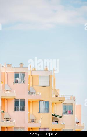 Vertikale Nahansicht einer mehrstöckigen Stufenfassade in sanftem Gelb und rosa Pastelltönen Stockfoto