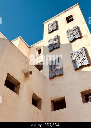 Blaue Holzläden an einem alten sonnendurchfluteten Gebäude in Agadir, Marokko Stockfoto