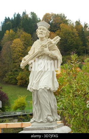 Religiöse Statue von Johannes von Nepomuk, Schutzpatron im Freien im Herbst. Stockfoto
