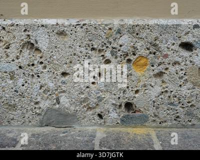Basis eines historischen Gebäudes aus Konglomerat mit abgerundeten Kieselsteinen und bunten Kieselsteinen. Nahaufnahme. Kopierraum. Stockfoto