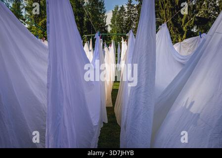 Weiße Laken trocknen an Seilen im Garten Stockfoto