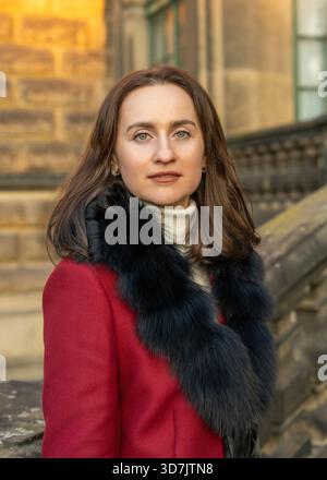 Elegante Reisende im Mantel, die die dresdner Altstadt entdecken und Alleintourismus, Architektur und authentische europäische Stadtatmosphäre hervorheben. Stockfoto