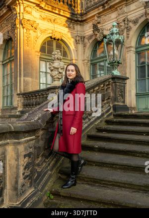 Elegante Reisende im Mantel, die die dresdner Altstadt entdecken und Alleintourismus, Architektur und authentische europäische Stadtatmosphäre hervorheben. Stockfoto