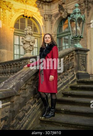 Elegante Reisende im Mantel, die die dresdner Altstadt entdecken und Alleintourismus, Architektur und authentische europäische Stadtatmosphäre hervorheben. Stockfoto