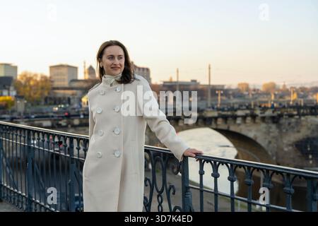 Junge Reisende in stilvollem Mantel erkunden Dresden, Deutschland, spazieren durch die Altstadt und erleben das europäische Stadtleben und Sightseeing. Stockfoto