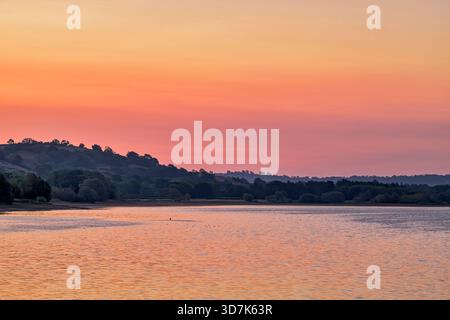 Sonnenaufgang am Blagdon Lake in Somerset mit niedrigem Wasserstand entlang der Küste während der Dürre im Sommer 2025. Stockfoto
