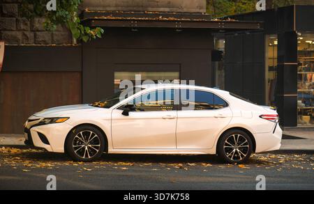 Jerewan Armenien 11.20.2025. Ein weißer Toyota-Wagen steht am Straßenrand. Das Auto steht vor einem Gebäude mit Fenster Stockfoto
