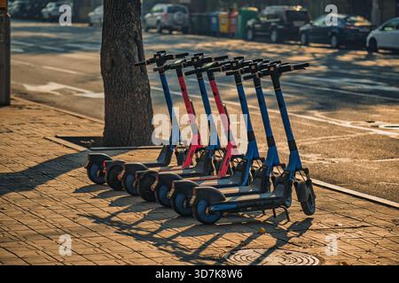 Jerewan Armenien 11.20.2025. Eine Reihe von Motorrollern befindet sich auf dem Bürgersteig. Die Roller sind blau und rot Stockfoto
