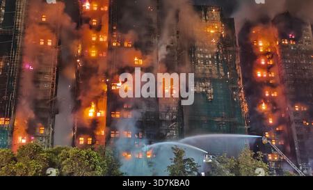 (251126) -- HONGKONG, 26. November 2025 (Xinhua) -- dieses Foto vom 26. November 2025 zeigt Retter, die an einer Feuerstelle für Wohngebäude in Hongkong, Südchina, arbeiten. Laut einer Pressemitteilung der Regierung der Sonderverwaltungsregion Hongkong (HKSAR) brach am Mittwochnachmittag ein Feuer in einem Wohngebäude im Tai Po-Gebiet aus. Die Feuerwehr der HKSAR-Regierung wurde gegen 14:51 Uhr Ortszeit über den Vorfall informiert. Aufgrund des heftigen Brandes löste die Abteilung den Alarm auf einen Alarmbrand Nr. 5 um 6 aus: Stockfoto