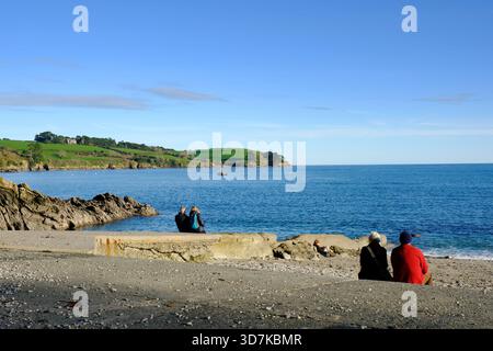 Menschen, die sich in der Wintersonne am Helford River, Cornwall, Großbritannien, entspannen Stockfoto