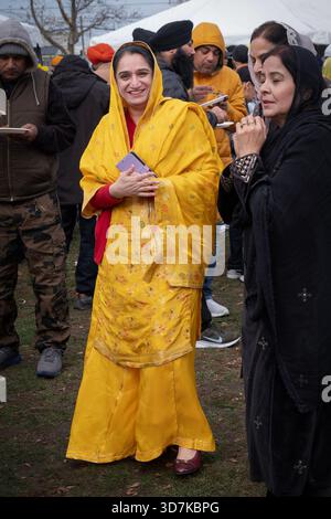 Eine wunderschöne, fromme Sikh-Frau in bescheidener Kleidung hängt mit Freunden vor einem Zelt im Gurmat Sammgam 2025 in Smoeky Park, Queens, NY ab. Stockfoto