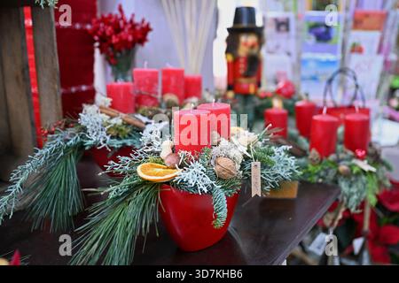 Leipzig, Deutschland. November 2025. Mehrere Adventskränze, die zu Weihnachten mit roten Kerzen dekoriert sind, stehen auf einem Schautisch in einem Blumenladen zum Verkauf. Der erste Advent ist für Christen die Zeit der Vorbereitung auf die Geburt Jesu. Der Advent, abgeleitet vom lateinischen Wort für Ankunft („adventus“), beginnt am Sonntag, der dem 30. November am nächsten ist, und endet am Weihnachtsfeiertag. Quelle: Jennifer Brückner/dpa/Alamy Live News Stockfoto