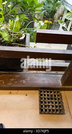Balkon mit Blick auf Topfpflanzen, Holzgeländer und Aschenbecher auf dem Boden Stockfoto