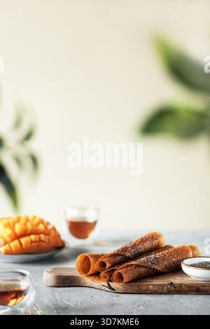 Helle Morgenszene mit tropischen Fruchtbrötchen und warmen Getränken Stockfoto