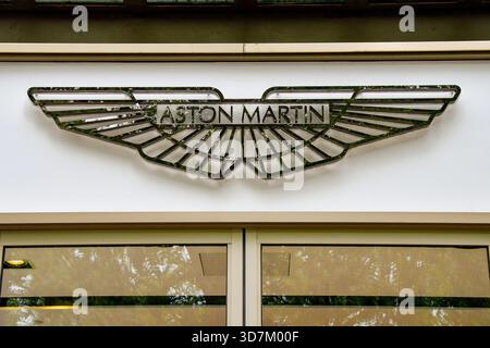 London, England, Großbritannien - 27. Juni 2023: Abzeichen des Autoherstellers Aston Martin über dem Eingang seines Ausstellungsraums in der Park Lane im Zentrum von London. Stockfoto
