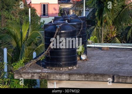 Zwei typische schwarze Kunststofftanks, die auf einem Dach eines Wohngebäudes in Bangladesch montiert sind. Ein gemeinsamer Anblick für die Trinkwasserversorgung in Südasien. Stockfoto