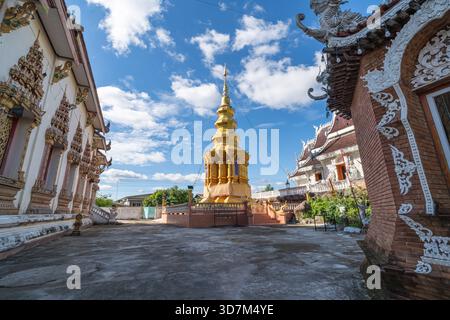 Dok KHAM TAI, THAILAND - 20. NOVEMBER 2025: Goldener Chedi und umliegende Tempelgebäude am Sri Chum Tempel in der Provinz Phayao, Nord-Thailand Stockfoto