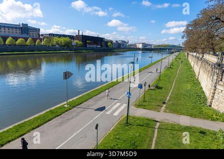 19. april 2025 Krakau, Polen. Die Weichsel (Wisla) und Menschen, die auf der Promenade am Wasser trainieren, fotografiert von Powstancow Slaskich bridg Stockfoto