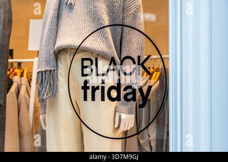 Nahaufnahme eines „Black Friday“-Schildes, das während des Werbezeitraums auf Englisch an der Schaufensterscheibe eines Bekleidungsgeschäfts geschrieben wurde Stockfoto