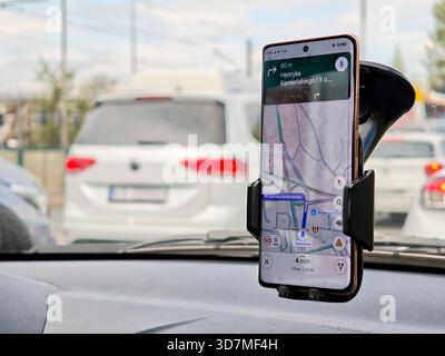Smartphone mit geöffneter Google Maps Navigations-App, Smartphone in einer Windschutzscheibenhalterung im Fahrzeug, Routenführung Geschwindigkeit warnt Stadtverkehr, Turn-by-tu Stockfoto