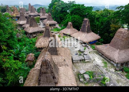 Blick aus der Vogelperspektive auf das traditionelle Dorf Kampung Tarung in der Nähe von Waikaboebak auf der Insel Sumba in Indonesien, berühmte sumbanesische Häuser mit hohen Dächern Stockfoto