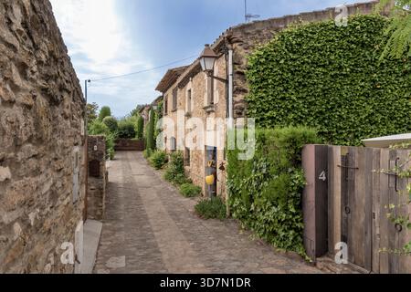 Kopfsteinpflasterallee, die sich zwischen alten Steinhäusern im historischen spanischen Dorf peratallada schlängelt Stockfoto