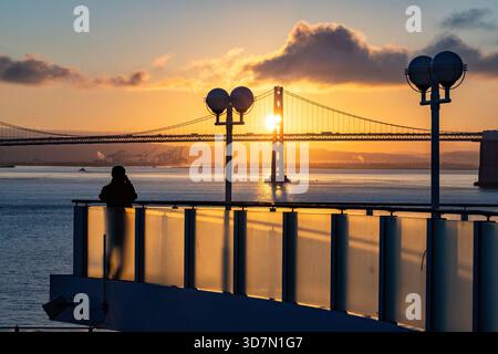 Touristen, die Fotos von der Bay Bridge (San Francisco-Oakland Bay Bridge) bei Sonnenaufgang von einem Kreuzfahrtschiff aus machen - San Francisco, Kalifornien, USA Stockfoto