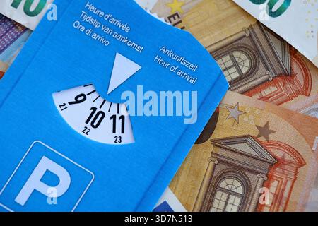 Europäische Parkscheibe mit Zeitwahl auf vielen Euro-Banknoten aus nächster Nähe. Das Konzept des Scheibenparksystems in europa Stockfoto