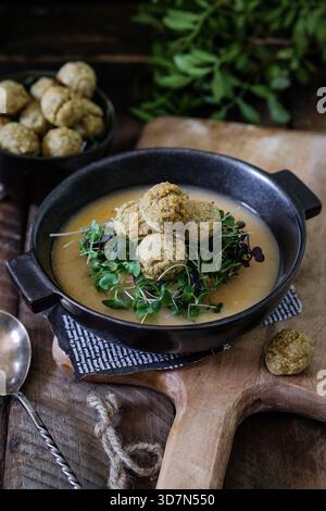 Beruhigende Brühe in rustikaler Holzschale mit Fleischbällchen Stockfoto