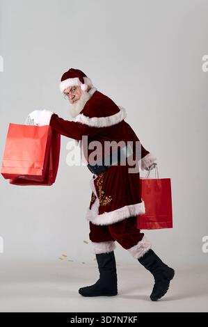 Ein Porträt des Weihnachtsmanns mit roten Paketen auf weißem Hintergrund Stockfoto