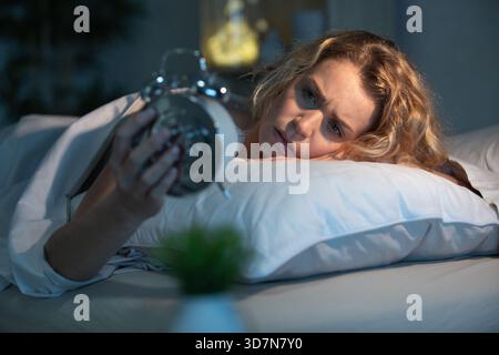 Eine junge Frau, die auf die Uhr schaut Stockfoto