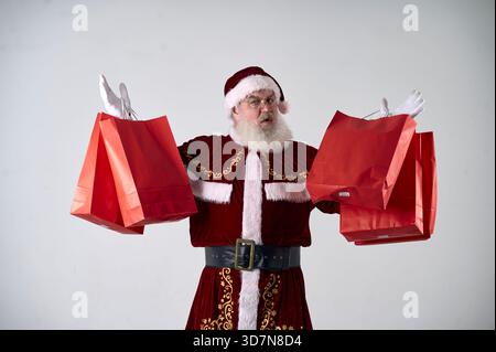 Ein Porträt des Weihnachtsmanns mit roten Paketen auf weißem Hintergrund Stockfoto