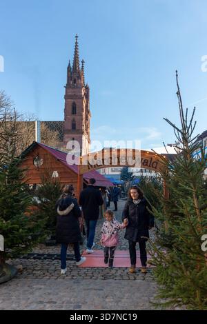 BASEL, SCHWEIZ - 16. DEZEMBER 2024: Besucher betreten den Abschnitt „Maerchenwald“ des Basler Weihnachtsmarktes mit Holzstollen Stockfoto