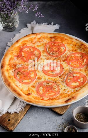 Pizza im Sommer mit Mozzarella und Basilikumblättern Stockfoto