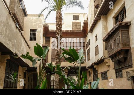 Traditionelle arabische Holzarbeiten Mashrabiyyas und Palmen im historischen Museumshaus von Bayt Al-Suhaymi in der Muiz Straße Stockfoto