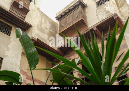 Traditionelle arabische Holzarbeiten Mashrabiyyas und Palmen im historischen Museumshaus von Bayt Al-Suhaymi in der Muiz Straße Stockfoto