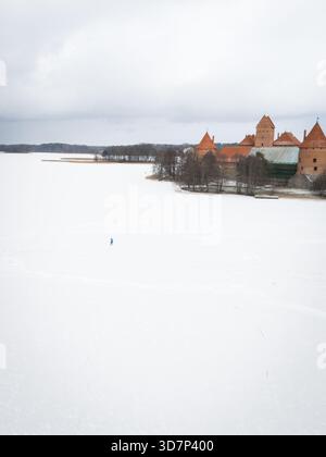 Aus der Vogelperspektive der mittelalterlichen Burg der Insel Trakai erhebt sich stolz auf die scharf weiße Weite des gefrorenen Galvė-Sees, Trakai, Litauen. Stockfoto