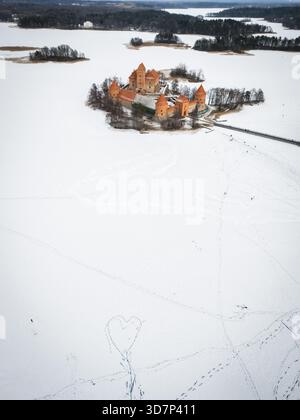 Die majestätische Trakai Island Castle aus der Vogelperspektive befindet sich inmitten des gefrorenen, schneebedeckten Sees, ein Zeugnis der Geschichte und Widerstandsfähigkeit, Trakai, Tra Stockfoto