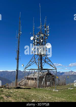 Stresa, Italien - 24. April 2025: Metallturm mit verschiedenen Telekommunikationsantennen auf einem Berg. Stockfoto