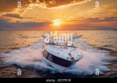 Luftaufnahme eines Motorschnellbootes, das während des goldenen Sonnenuntergangs im Sommer über das Meer fährt Stockfoto