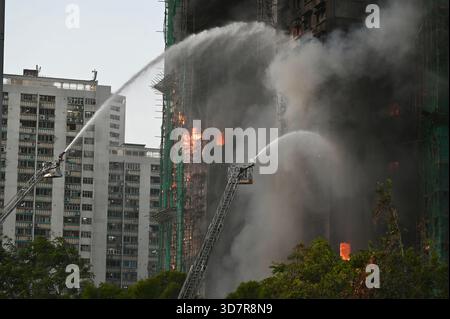 Hongkong, China. 26. November 2025. Es werden Anstrengungen unternommen, die Flammen zu löschen, wenn ein Brand am 26. November 2025 in Hongkong, China, Hochhäuser im Wang Fuk Court Complex erfasst. Mindestens vier Menschen sind tot und drei weitere verletzt, als ein Großbrand am 26. November einen Wohnkomplex im Tai Po Bezirk in Hongkong überfiel. Credit: Li Zhihua/China News Service/Alamy Live News Stockfoto