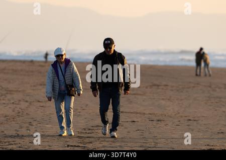 Seniorenpaar spazieren am Ocean Beach in San Francisco bei Sonnenuntergang Stockfoto