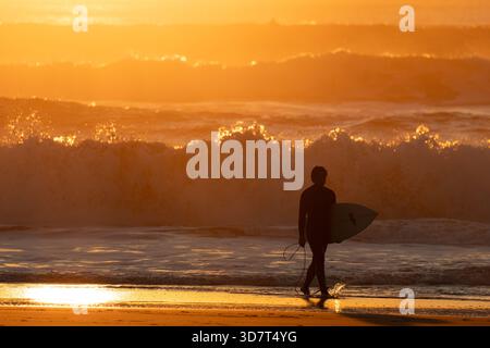 Surfer spazieren am Ocean Beach bei Sonnenuntergang in San Francisco Stockfoto