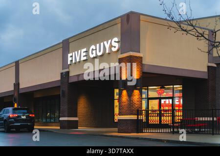 DeWitt, NY - 23. November 2025: Night View of Five Guys, eine globale Fast-Casual-Restaurantkette, die sich auf individuelle Burger, frisch geschnittene Pommes Frites, Stockfoto