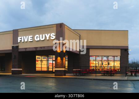DeWitt, NY - 23. November 2025: Night View of Five Guys, eine globale Fast-Casual-Restaurantkette, die sich auf individuelle Burger, frisch geschnittene Pommes Frites, Stockfoto