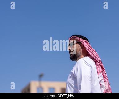 Mann mit traditioneller arabischer Kleidung, der draußen in der Stadt läuft. Schönes sonniges Wetter. Hochwertige Fotos Stockfoto